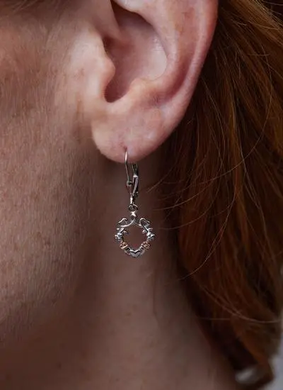Close up shot of red haired model wearing Sterling Silver Shamrock Claddagh Heart Earrings